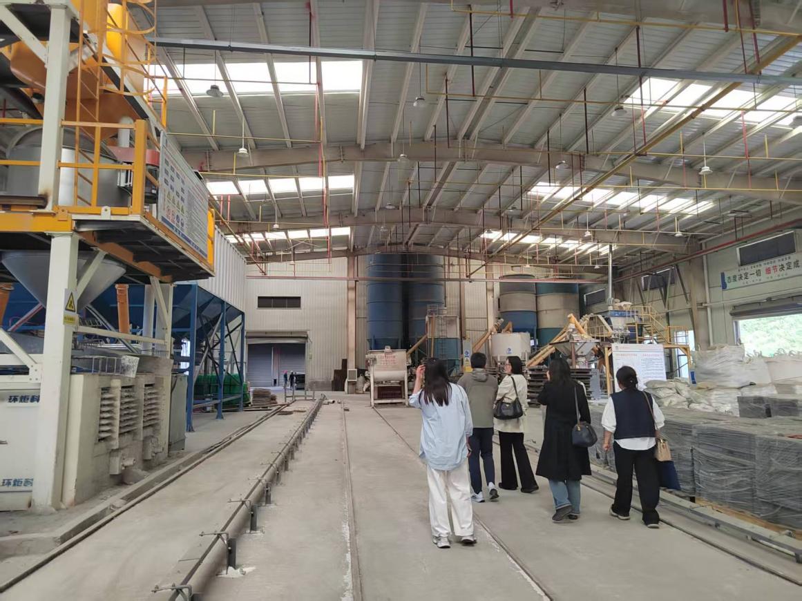 Visitors inspecting production facilities at Qujing Huanju